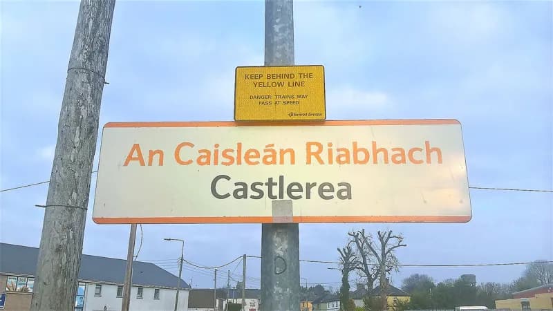 Panneau de gare bilingue : An Caisleán Riabhach au-dessus de Castlerea.