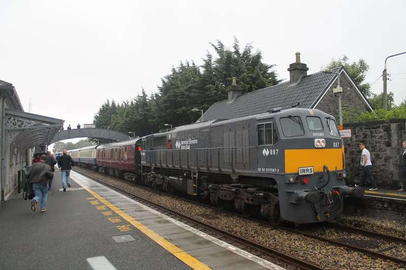 Uma locomotiva na plataforma de Castlerea, com a cobertura moderna e a linha amarela visíveis.