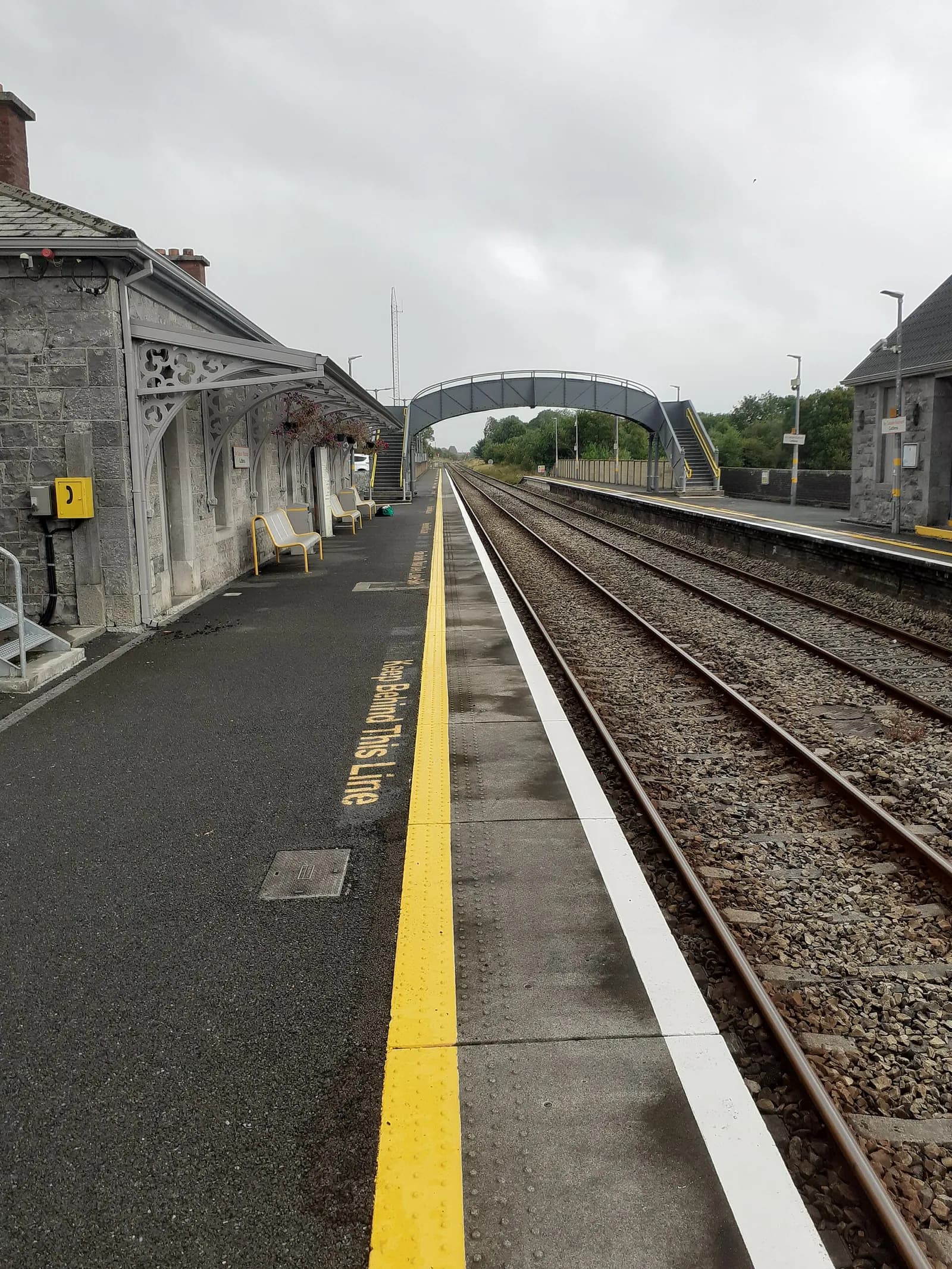 Der Bahnsteig in Castlerea entlang des Gleises gesehen, leer, mit der gelben Sicherheitslinie.